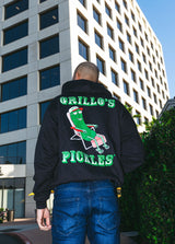 back of man in street wearing black hoodie with "grillo's pickles" and pickle in lounge chair 