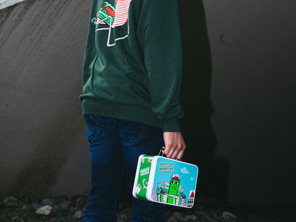 lower body of human holding grillo's pickles lunchbox