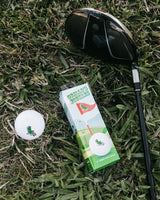 golf ball packing next to club in grass